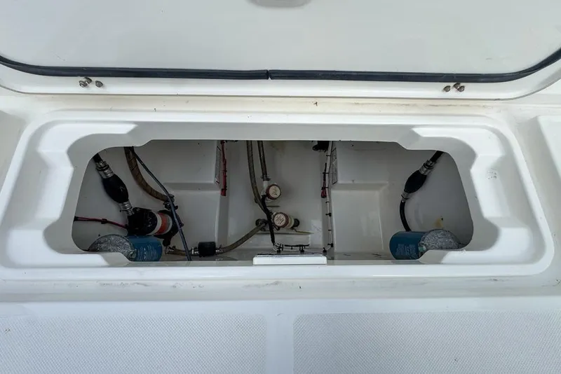 Slide: The Image of Open storage compartment of a 2000 Century 3200 Center Console boat, showing internal components. - 60