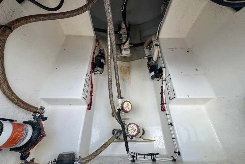 Slide: The Image of Interior view of a 2000 Century 3200 Center Console boat's bilge area with hoses and pumps. - 62