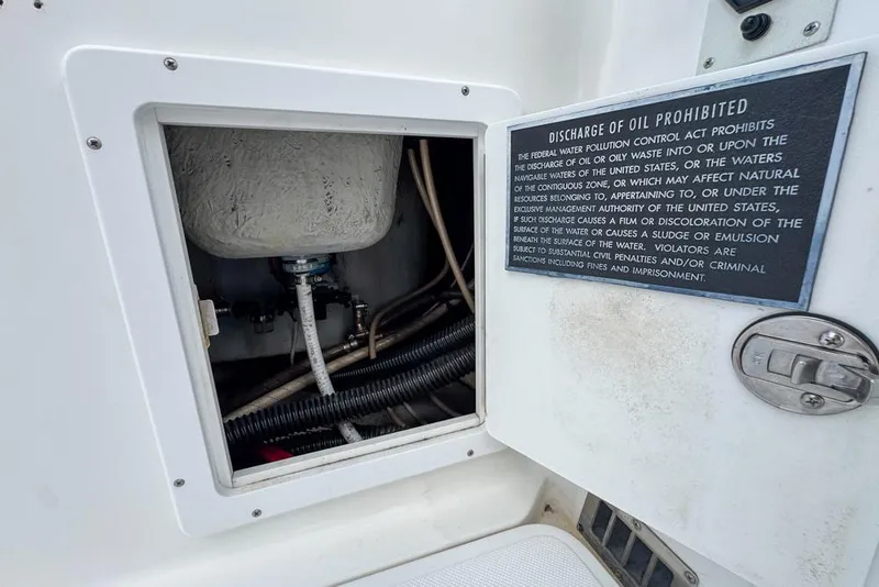 Slide: The Image of Open compartment on 2000 Century 3200 Center Console with oil discharge warning sign. - 64