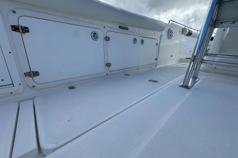 Slide: The Image of 2000 Century 3200 Center Console boat deck with storage compartments and metal ladder. - 68