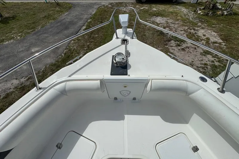 Slide: The Image of 2000 Century 3200 Center Console boat bow with anchor and railing, parked on grass. - 87