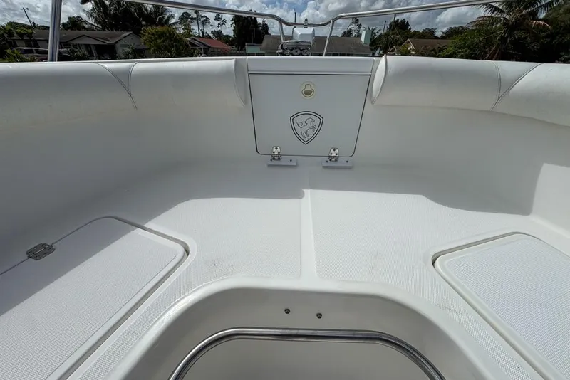 Slide: The Image of 2000 Century 3200 Center Console boat interior with white seating and storage compartment. - 90