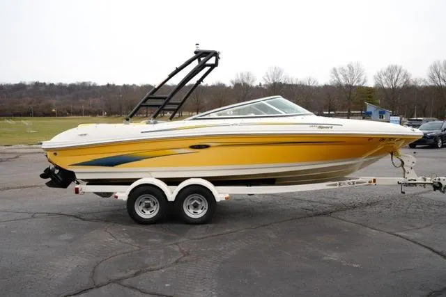 Slide: The Image of 2006 Sea Ray 205 Sport boat in yellow on a trailer, parked outdoors. - 4