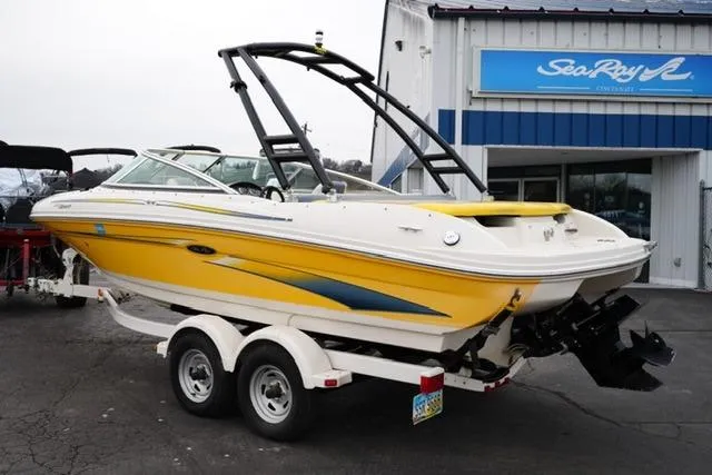 Slide: The Image of 2006 Sea Ray 205 Sport boat in yellow on trailer, parked outside dealership. - 7