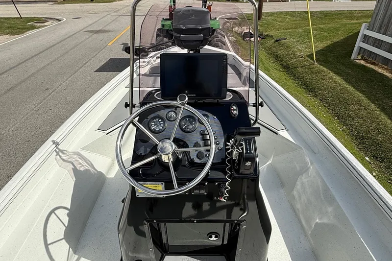 Slide: The Image of 2020 Excel 203 Bay Pro boat dashboard with steering wheel and navigation equipment. - 11