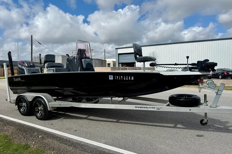 Slide: The Image of 2020 Excel 203 Bay Pro boat on trailer, parked outdoors under cloudy sky. - 5