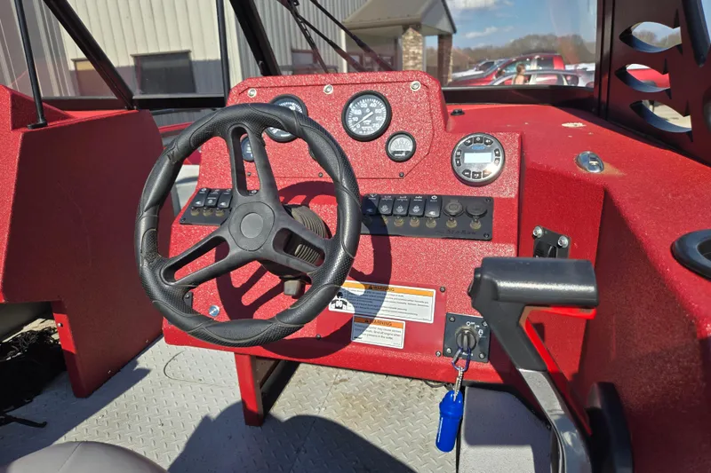 Slide: The Image of 2023 SeaArk ProCat 240 boat dashboard with steering wheel and control panel. - 12