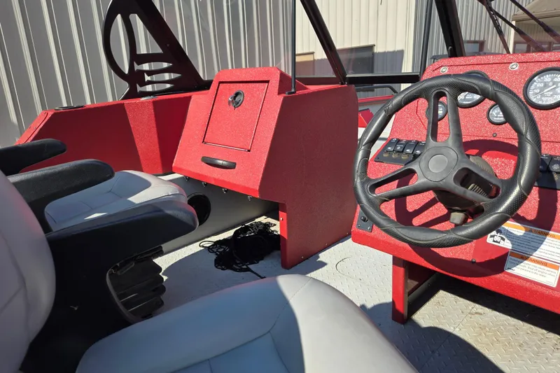 Slide: The Image of 2023 SeaArk ProCat 240 boat interior with red dashboard and steering wheel. - 13