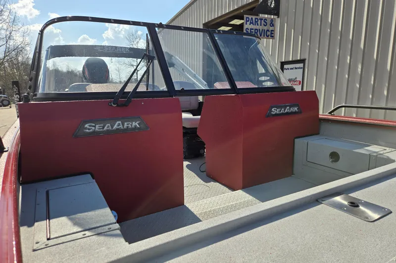 Slide: The Image of 2023 SeaArk ProCat 240 boat with red console, parked near parts and service building. - 14