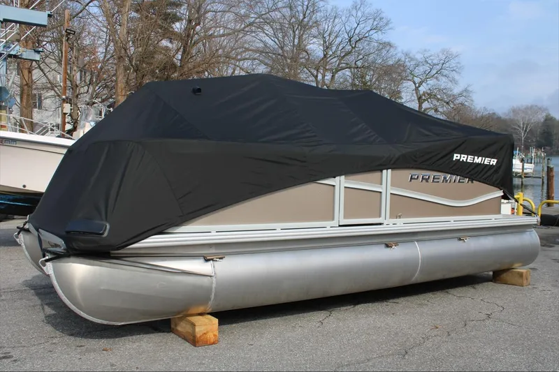 Slide: The Image of 2026 Premier 200 Sunscape RF - CL pontoon boat with black cover, parked on blocks. - 12
