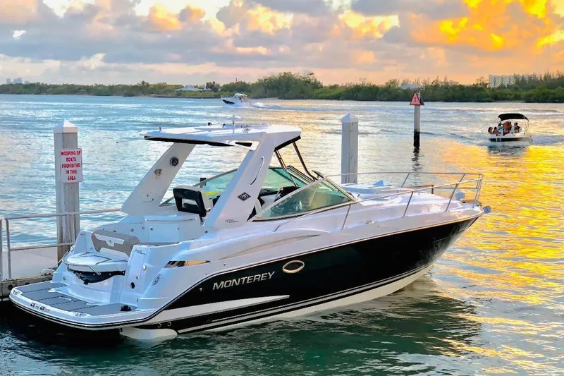 The Image of 2018 Monterey 335 Sport Yacht docked at sunset, reflecting on calm waters. - 0