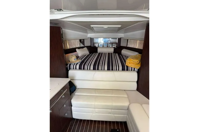 Slide: The Image of 2018 Monterey 335 Sport Yacht interior with striped bedding and modern furnishings. - 10