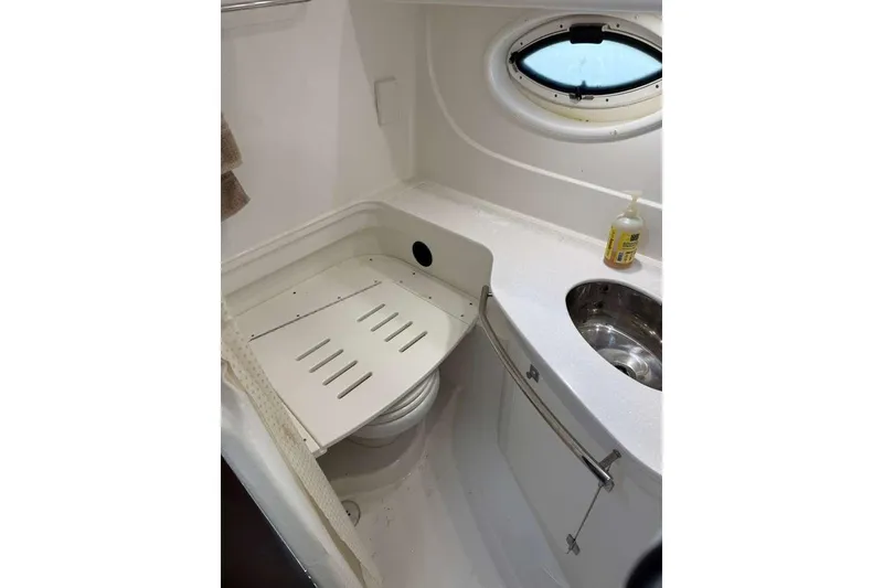 Slide: The Image of 2018 Monterey 335 Sport Yacht bathroom with sink, porthole, and storage. - 11