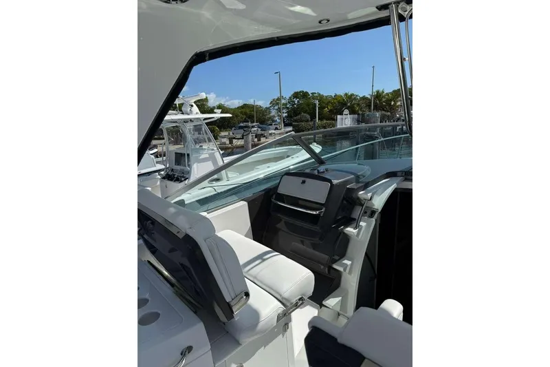 Slide: The Image of 2018 Monterey 335 Sport Yacht cockpit with modern controls and seating, docked at marina. - 4