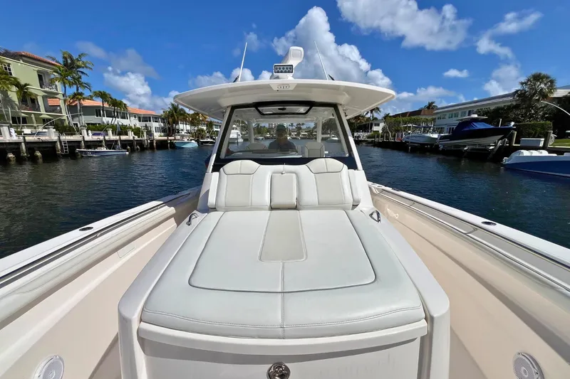 Slide: The Image of 2019 Pursuit S 368 Sport boat on a sunny waterfront, showcasing luxurious seating. - 11