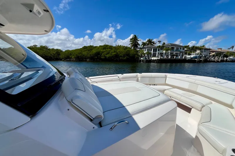 Slide: The Image of 2019 Pursuit S 368 Sport boat on calm water, luxury waterfront homes in background. - 12