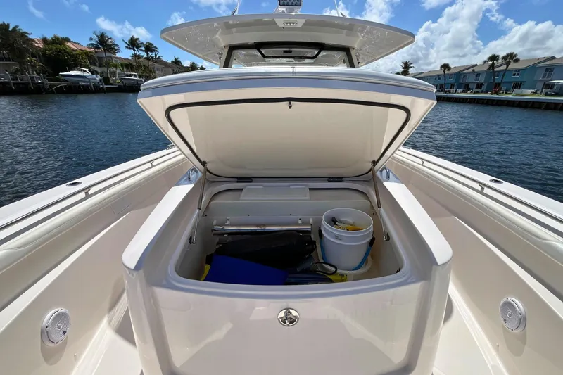 Slide: The Image of 2019 Pursuit S 368 Sport boat with open storage compartment, dockside view. - 13