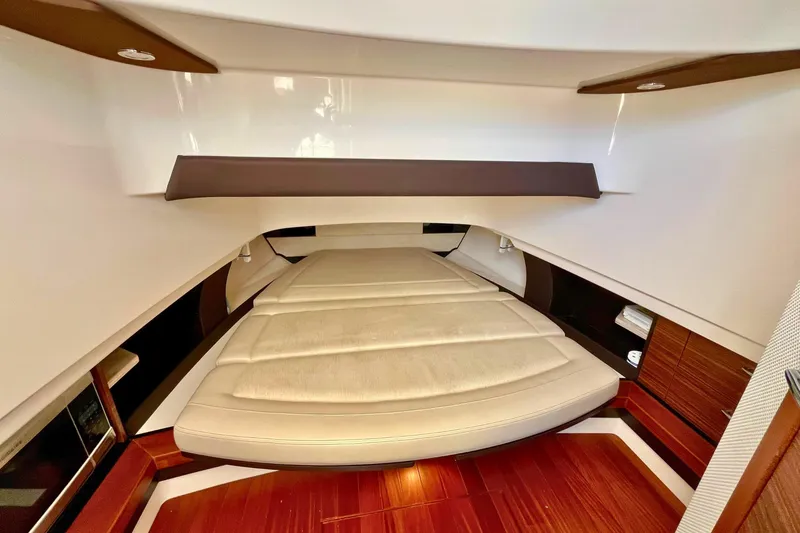 Slide: The Image of 2019 Pursuit S 368 Sport cabin interior with luxurious bedding and wooden accents. - 2