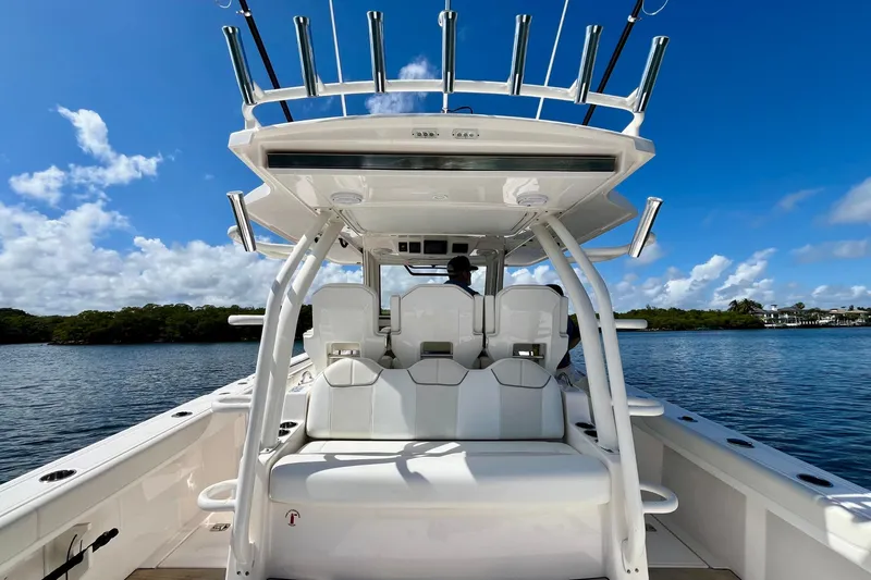 Slide: The Image of 2019 Pursuit S 368 Sport boat interior with seating, rod holders, and scenic water view. - 29