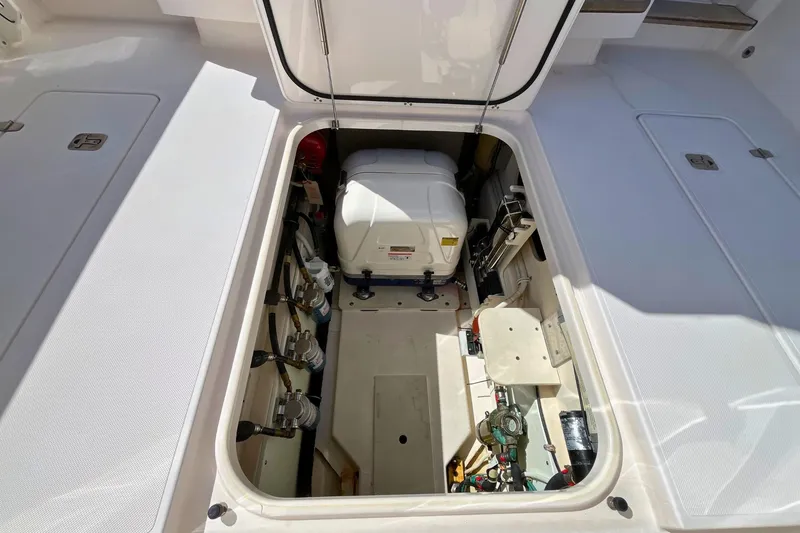 Slide: The Image of 2019 Pursuit S 368 Sport boat engine compartment, showcasing equipment and storage space. - 30