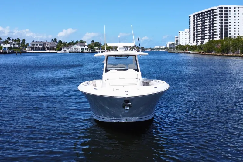 Slide: The Image of 2019 Pursuit S 368 Sport boat on calm water with cityscape background. - 38