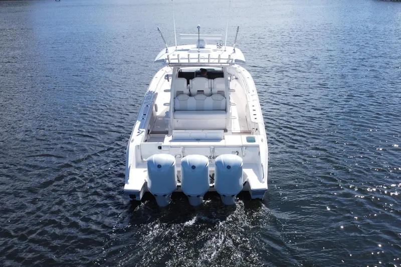Slide: The Image of 2019 Pursuit S 368 Sport boat cruising on open water, rear view. - 41