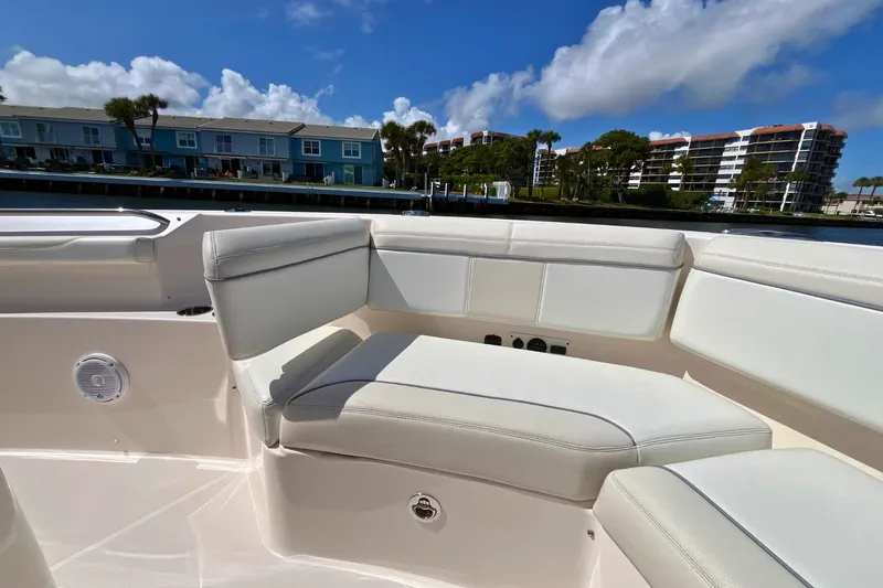 Slide: The Image of 2019 Pursuit S 368 Sport boat interior with white seating, dockside view. - 7