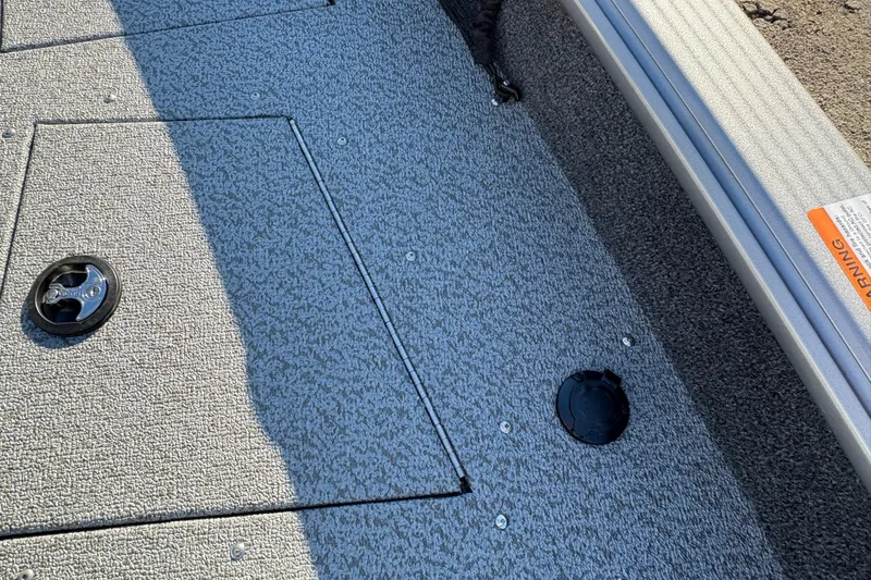 Slide: The Image of 2025 Lund 1875 Pro Guide boat deck with textured surface and storage compartments. - 15