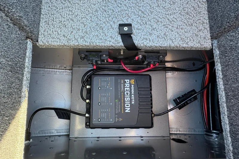 Slide: The Image of 2025 Lund 1875 Pro Guide boat battery compartment with Minn Kota Precision charger. - 19