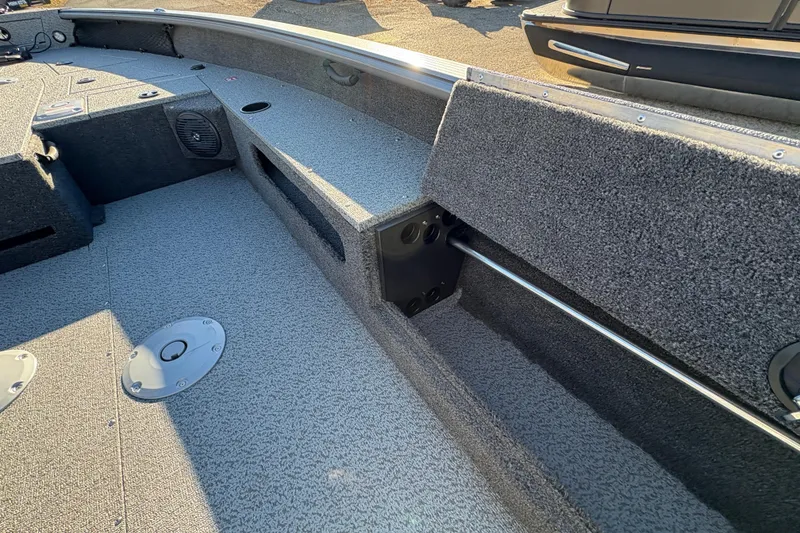 Slide: The Image of 2025 Lund 1875 Pro Guide boat interior with storage compartments and carpeted flooring. - 23