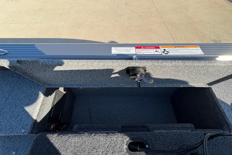 Slide: The Image of 2025 Lund 1875 Pro Guide boat interior with storage compartment and safety warnings. - 33