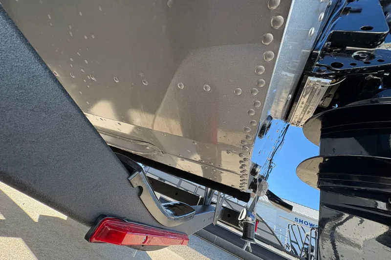 Slide: The Image of 2025 Lund 1875 Pro Guide boat hull and motor detail, showcasing rivets and trailer. - 42