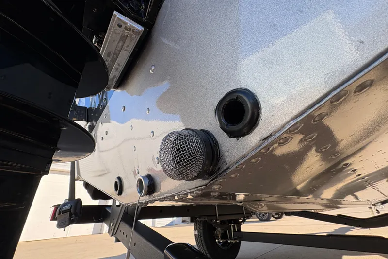 Slide: The Image of 2025 Lund 1875 Pro Guide boat hull detail with drain plug and trailer. - 44