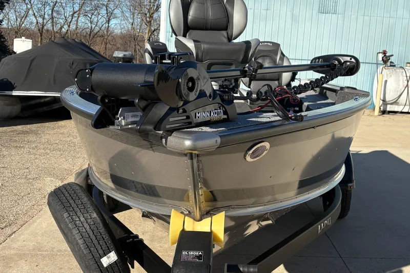 Slide: The Image of 2025 Lund 1875 Pro Guide boat with Minn Kota trolling motor, parked outdoors. - 6