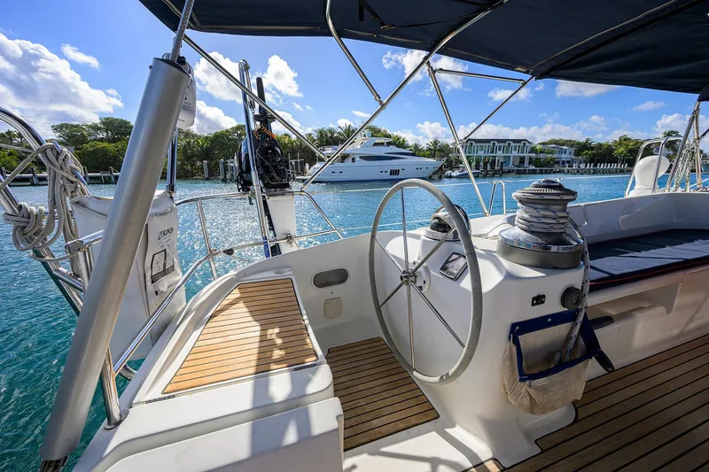 Slide: The Image of Cockpit of 2003 Beneteau 50 sailboat with steering wheel, overlooking marina and luxury yacht. - 15