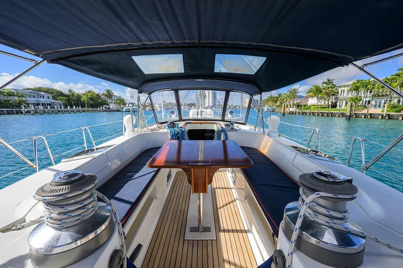 Slide: The Image of Luxurious 2003 Beneteau 50 yacht cockpit with seating, table, and winches, docked by waterfront homes. - 16