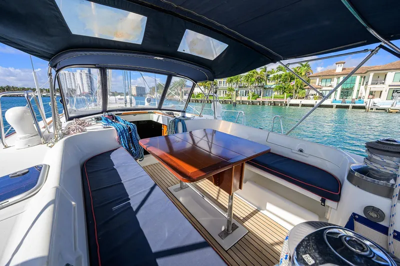 Slide: The Image of Cockpit of 2003 Beneteau 50 sailboat with seating, table, and waterfront view. - 17