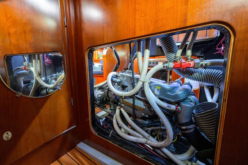 Slide: The Image of Engine room of a 2003 Beneteau 50 yacht, showcasing complex machinery and hoses. - 23
