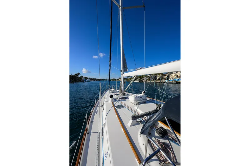 Slide: The Image of 2003 Beneteau 50 sailboat on calm water under clear blue sky. - 27