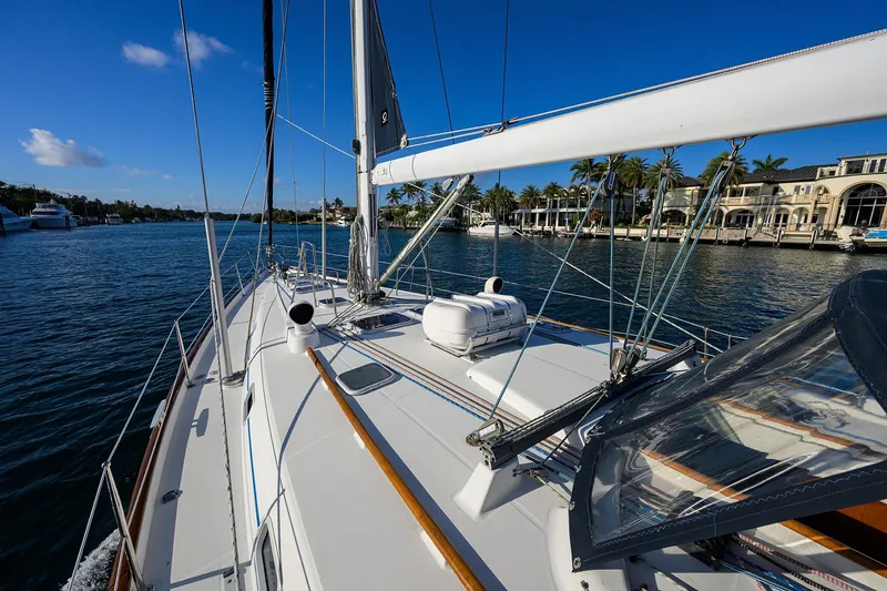 Slide: The Image of 2003 Beneteau 50 sailboat on a sunny day, cruising near luxury waterfront homes. - 28