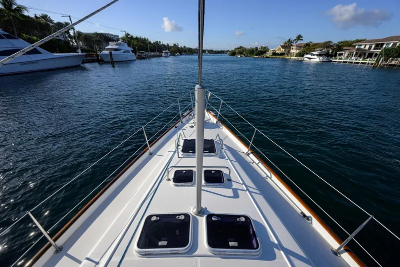 Slide: The Image of Bow view of 2003 Beneteau 50 yacht navigating a serene waterway. - 29