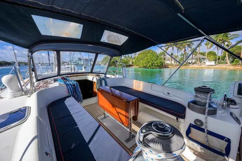 Slide: The Image of Cockpit view of 2003 Beneteau 50 sailboat with seating, overlooking tropical waters and palm trees. - 3