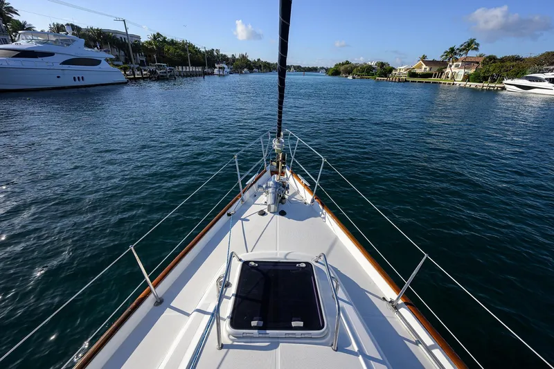 Slide: The Image of Bow view of 2003 Beneteau 50 yacht navigating a serene waterway. - 30