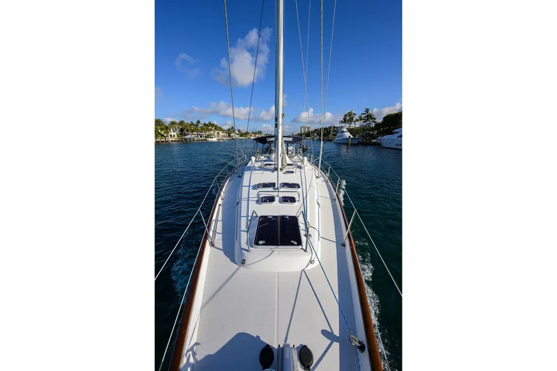Slide: The Image of 2003 Beneteau 50 sailboat on calm water, clear sky, and coastal view. - 31