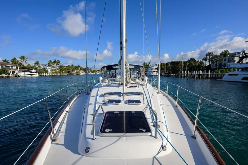 Slide: The Image of 2003 Beneteau 50 sailboat on calm water, clear sky, and coastal view. - 33