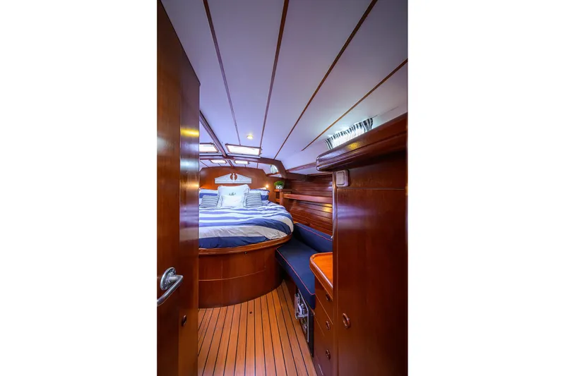 Slide: The Image of Luxurious cabin interior of 2003 Beneteau 50 yacht with wooden finish and cozy bed. - 50