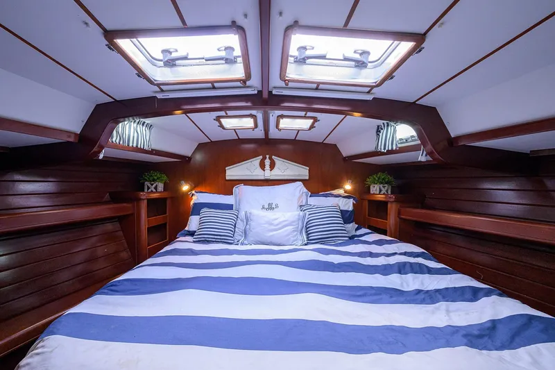 Slide: The Image of Luxurious cabin interior of a 2003 Beneteau 50 yacht with striped bedding and wooden accents. - 53