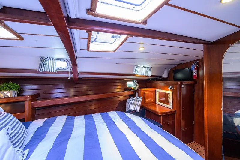 Slide: The Image of Luxurious cabin interior of 2003 Beneteau 50 yacht with striped bedding and wooden finishes. - 54