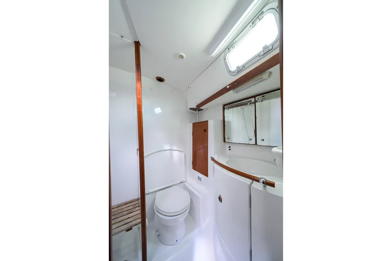 Slide: The Image of Bathroom interior of 2003 Beneteau 50 yacht, featuring toilet, sink, and mirror. - 58