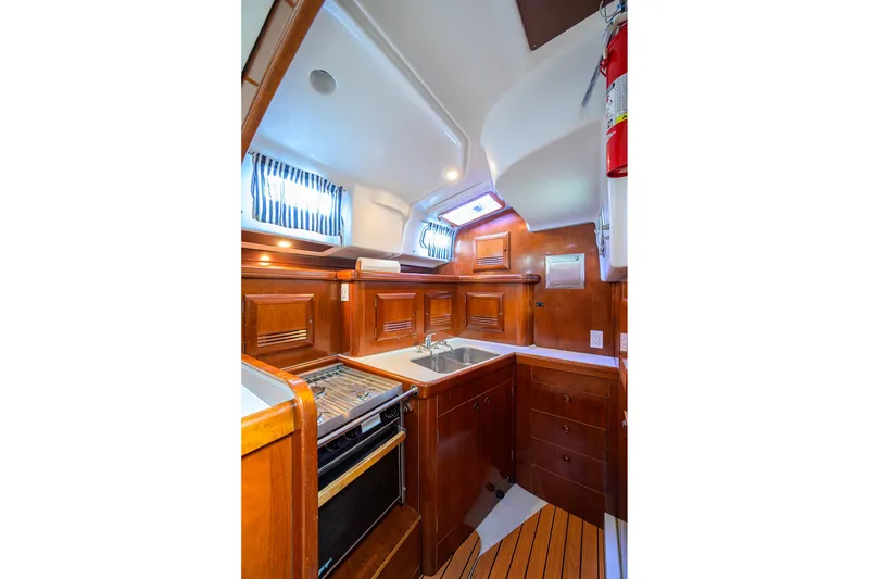Slide: The Image of Luxurious 2003 Beneteau 50 yacht kitchen with wood cabinetry and modern appliances. - 63